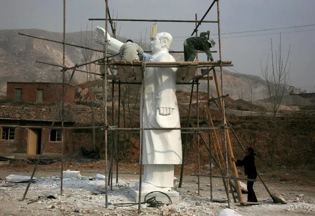 Sculptors work as they stand on scaffolding surrounding a statue of the late Chinese chairman Mao Zedong in the town of Dangcheng, located 250km (155 miles) southwest of Beijing, March 23, 2009. (Photo by David Gray/Reuters)
