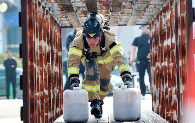 At the Daejeon Firefighting Skills Competition held at the 119 Special Response Unit in Yuseong-gu, Daejeon on April 3, 2025 a firefighter who participated in the strongest firefighter category in the rescue category is passing through an obstacle while holding a bucket filled with 20 kg of sand. (Photo by Shin Hyeon-jong)