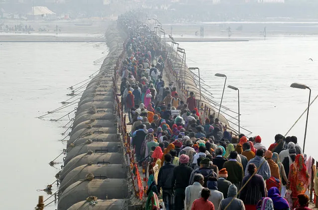 Devotees cross a pontoon bridge after taking a holy dip at Sangam, the confluence of the Ganges, Yamuna and Saraswati rivers, during Magh Mela festival in Allahabad, India, January 15, 2018. (Photo by Jitendra Prakash/Reuters)