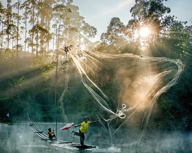A fisherman casts his net into Cileunca lake in West Java, Indonesia in the last decade of December 2022. (Photo by Lia Indriani/Solent News)