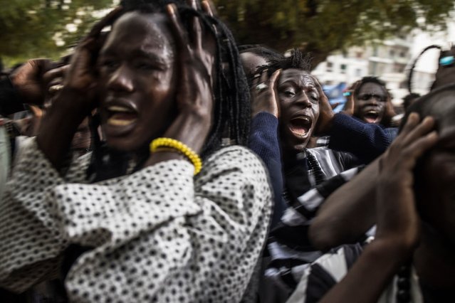 Baye Fall followers chant during a celebration as they return from the Great Mosque in Touba to the house of Sheik Ndiguel Fall, a local marabout, on March 20, 2024. The Baye Fall is a Senegalese Muslim Sect and a branch of the Mouride brotherhood, Senegal's largest Muslim brotherhood. The Baye Fall believe that physical labour, which can consist of farming, construction work and cooking, is an act of prayer and devotion. They are also well known for their colourful clothing dreadlocks and mass chanting. (Photo by Marco Longari/AFP Photo)