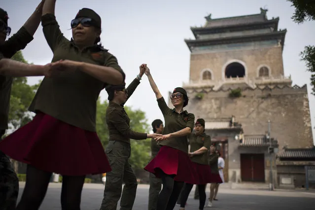 Line dancing clubs are hugely popular throughout China. A group of women do their routine in front of the ancient Bell Tower in the old district of Beijing on May 19, 2016. (Photo by Michael Robinson Chavez/The Washington Post)