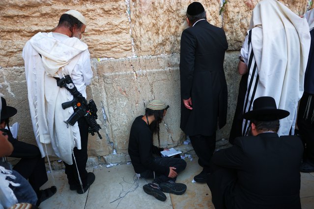 Orthodox Jews pray as they read from the book of Eicha (Book of Lamentations) to mark Tisha B'av, at The Western Wall, in the Old City of Jerusalem, 03 August 2025. In Judaism, the Tisha B'Av is an annual fasting day marking the destruction of the first and the second temple by the Babylonian and the Roman Empires in Jerusalem. During Tisha B'av, Ultra-Orthodox Jews stay up all night and sleep at the Western Wall as they recite lamentations focusing on the destruction of the ancient temple, that was located on the other side of the ancient wall, on the Temple Mount. (Photo by Abir Sultan/EPA)