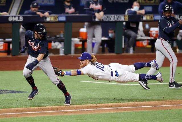 Dansby Swanson #7 of the Atlanta Braves is tagged out by Justin Turner #10 of the Los Angeles Dodgers in a rundown between third base and home plate during the fourth inning in Game Seven of the National League Championship Series at Globe Life Field on October 18, 2020 in Arlington, Texas. (Photo by Tom Pennington/Getty Images)