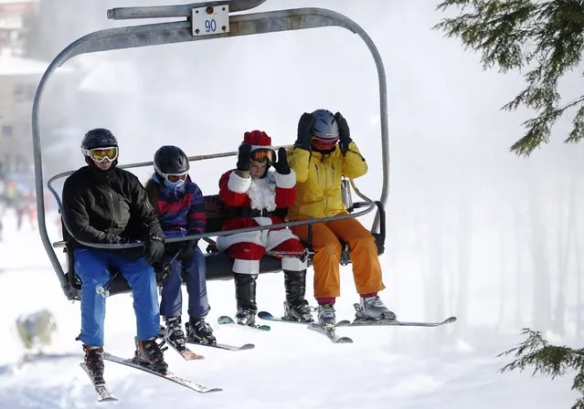 A skier dressed as Santa Claus rides a lift after participating in a charity run down a slope at Sunday River Ski Resort in Newry, Maine December 7, 2014. (Photo by Brian Snyder/Reuters)