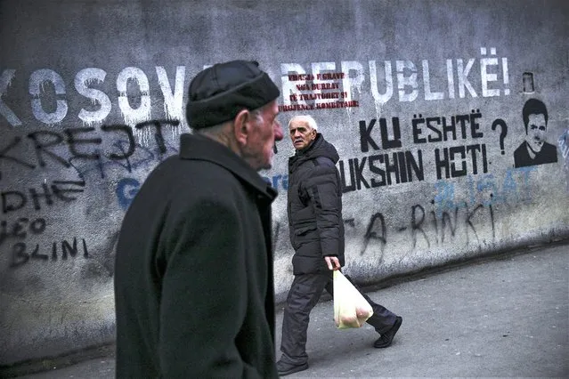 Kosovan Albanians walk past a mural reading “Republic of Kosova” in Pristina on February 27, 2023. Brussels hosts the rival leaders of Kosovo and Serbia on February 27, 2023 as the European Union turns up the pressure to reach a breakthrough deal it hopes will lead to a normalisation of ties between the foes. (Photo by Armend Nimani/AFP Photo)