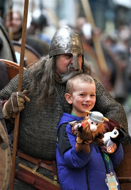 A youngster poses for a picture with a Viking re-enactor during a march through York during the Yorvik Viking Festival on February 18, 2023 in York, England. The march through the city and skirmishing is part of a week of family friendly activities in York based around the Jorvik Viking Festival. The activities include Viking encampments, archaeological discoveries, crafting, sword combat sessions, best beard competition, skirmishes and a contest between four warring factions of Vikings which all aim to show the Norse heritage of the region and the connection with York. (Photo by Ian Forsyth/Getty Images)