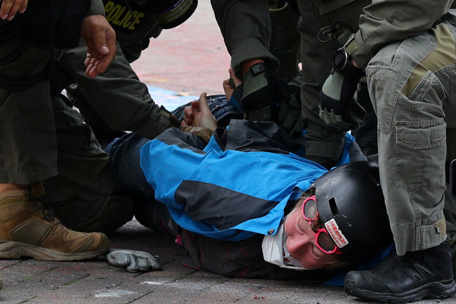 Law enforcement officers detain a protester outside the ICE headquarters in Portland, Oregon, U.S., October 4, 2025. (Photo by Carlos Barria/Reuters)