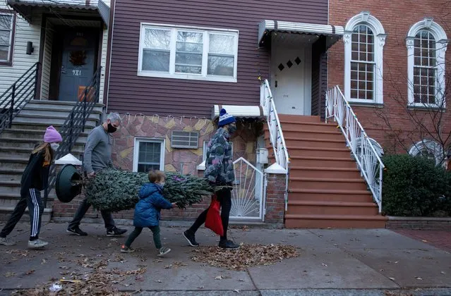 The Hassebroek family carries a Christmas tree home, as the global outbreak of the coronavirus disease (COVID-19) continues, in New York City, U.S., December 6, 2020. (Photo by Caitlin Ochs/Reuters)
