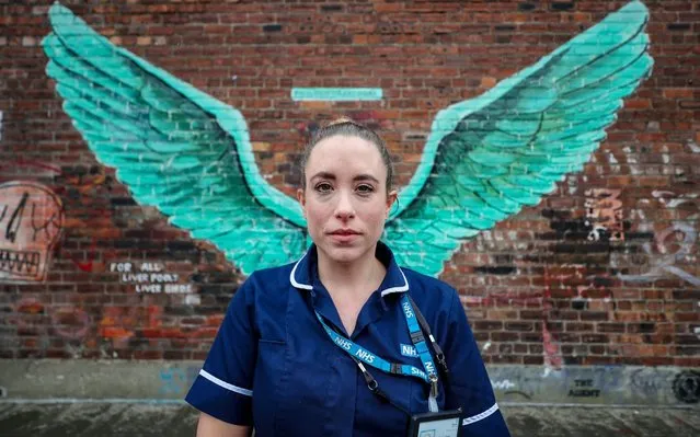 Erica Daly, a District Nurse Team Leader at Mersey Care NHS, stands in front of the “Liver Bird Wings”, an artwork by Paul Curtis on a wall within LIverpool's Baltic Triangle on April 29, 2020. (Photo by Peter Byrne/PA Images via Getty Images)
