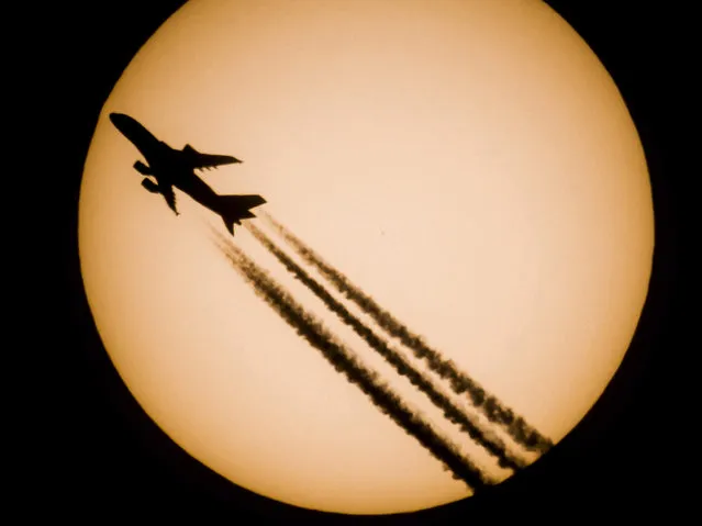 An Airbus A380-861 passenger jet of Singapore Airlines is silhouetted against the Sun as photographed from Salgotarjan, 109 kms northeast of Budapest, Hungary, 28 October 2016. (Photo by Peter Komka/EPA)