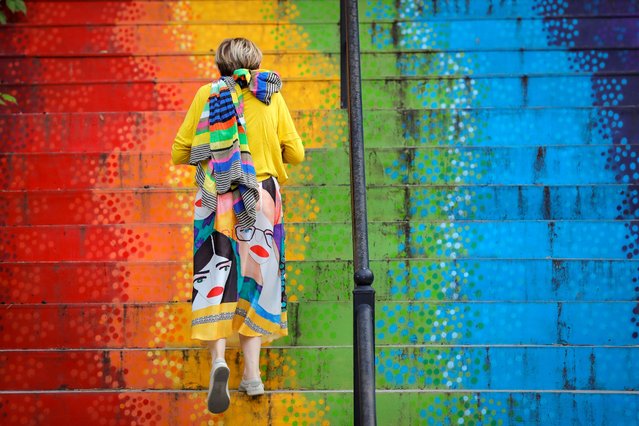 A woman walks up a stairway painted in the rainbow colors in Bucharest, Romania, Saturday, July 11, 2020. Romania reported 698 new COVID-19 infections in the last 24 hours, the highest level since the pandemic reached the country in February. (Photo by Vadim Ghirda/AP Photo)