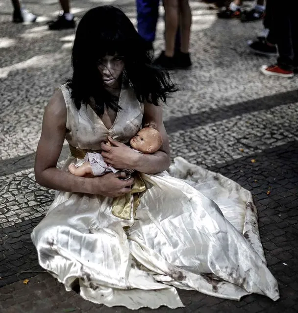 A woman takes part in the Zombie Walk in Sao Paulo, Brazil on November 2, 2016. Hundreds of people took to the streets in traditional costumes of zombies, witches, vampires and horror characters during the 11 th edition of the Zombie Walk SP, held since 2006 on the Day of the Dead. (Photo by Miguel Schincariol/AFP Photo)