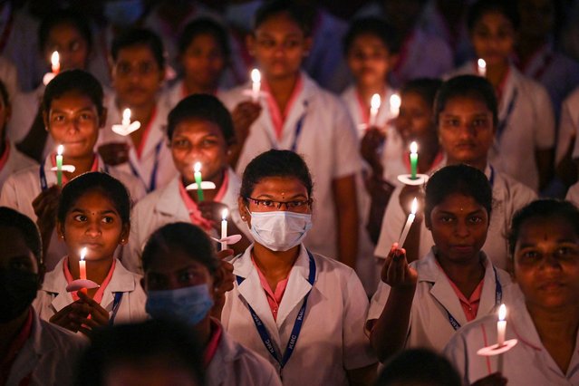 Health workers light candles to mark “international nurses day” at a government medical college in Chennai on May 12, 2023. (Photo by R.Satish Babu/AFP Photo)