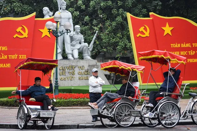 People wait for customers next to a poster of the 13th National Congress of the Communist Party of Vietnam in Hanoi, Vietnam, January 25, 2021. (Photo by Thanh Hue/Reuters)