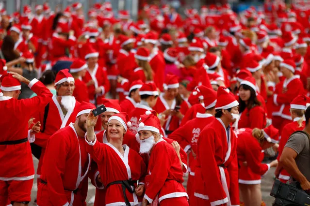 People dressed as Santa gather on Queens Wharf before the annual KidsCan Santa Fun Run on December 2, 2015 in Auckland, New Zealand. The annual event takes place in 18 venues across New Zealand. (Photo by Phil Walter/Getty Images)