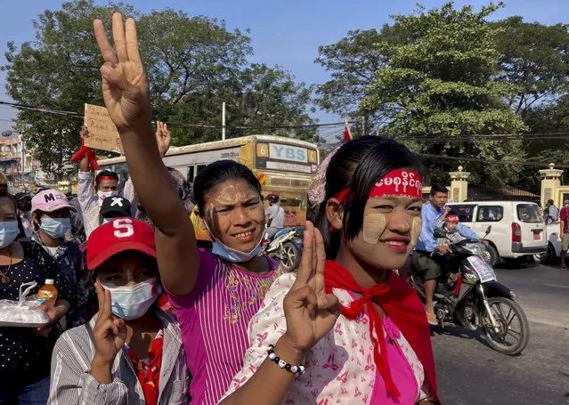 Demonstrators flash three-fingered salute against the military coup in Yangon, Myanmar Thursday, February 12, 2021. Large crowds demonstrating against the military takeover in Myanmar again defied a ban on protests, even after security forces ratcheted up the use of force against them. (Photo by AP Photo/Stringer)