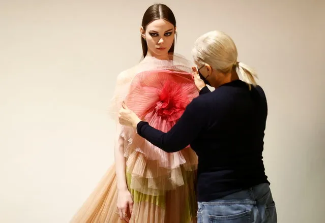 Maria Grazia Chiuri, designer for Fashion house Dior, poses with a model during an interview with Reuters ahead of her Fall/Winter 2021 collection presentation in a digital format during Paris Fashion week, in Aubervilliers, near Paris, France, March 6, 2021. (Photo by Christian Hartmann/Reuters)