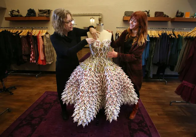 In this photo taken Thursday, February 5, 2015, Marjorie Taylor, left, and her daughter Amber Taylor, co-owners of Velvet Edge in Eugene, Ore. prepare a dress constructed from recycled casino cards for display at their boutique to celebrate Valentine's Day. (Photo by Chris Pietsch/AP Photo/The Register-Guard)