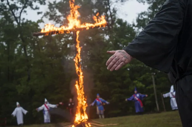 A tattoo on the knuckles of a Klansman reads Love as he participates with members of the Nordic Order Knights and the Rebel Brigade Knights, groups that both claim affiliation with the Ku Klux Klan, in a cross lighting ceremony on a fellow member's property in Henry County, Virginia, August 9, 2014. The Ku Klux Klan, which had about 6 million members in the 1920s, now has some 2,000 to 3,000 members nationally in about 72 chapters, or klaverns, according to the Southern Poverty Law Center, an organization that monitors extremist groups. (Photo by Johnny Milano/Reuters)