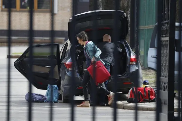 Embassy staff prepare to load luggage into a car inside the Czech Republic Embassy in Moscow, Russia, Monday, April 19, 2021. Russia has ordered 20 Czech diplomats to leave the country within a day in response to Prague's expulsion of 18 Russian diplomats. The Czech government has alleged the Russian Embassy staffers were spies for a military intelligence agency that was involved in a fatal ammunition depot explosion in 2014. (Photo by Pavel Golovkin/AP Photo)