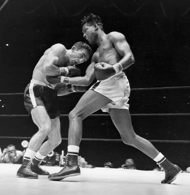 World middleweight champion Sugar Ray Robinson, right, gets through the guard of challenger Carmen Basilio and drives a right to the midsection in fifth round of middleweight title fight at Yankee Stadium in New York, in this September 23, 1957 file photo. Basilio won the title with a 15-round decision over Robinson. (Photo by AP Photo)