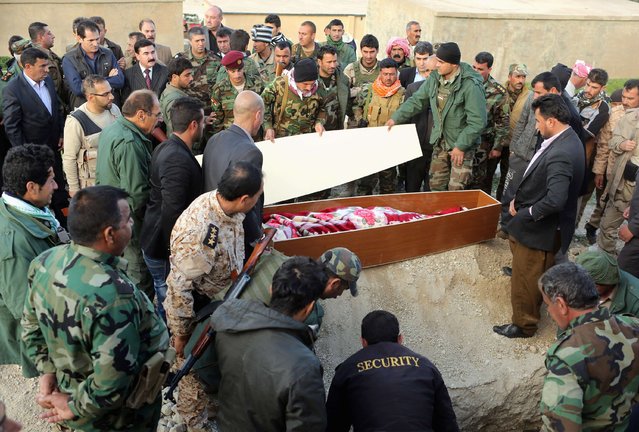 ATTENTION EDITORS - VISUAL COVERAGE OF SCENES OF INJURY OR DEATH
Members of the Peshmerga and relatives of a Peshmerga fighter killed in a suicide attack in Sinjar province, attend a burial ceremony at Mazar Sharaf Eldin, a sacred and cemetery area for the Yazidi minority, north of Sinjar, March 2, 2015. A number of Peshmerga were killed and others injured after two suicide car bombs attacks targeted a building the Peshmerga were using for fighting. REUTERS/Asmaa Waguih  TEMPLATE OUT