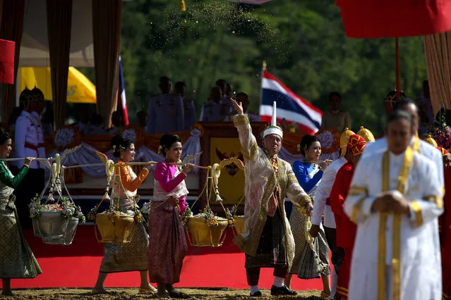 Lertviroj Kowattana, permanent secretary of the Thai Ministry of Agriculture and Cooperatives (C), dressed in a traditional costume, throws rice grains during the annual royal ploughing ceremony in central Bangkok, Thailand, May 14, 2018. (Photo by Athit Perawongmetha/Reuters)