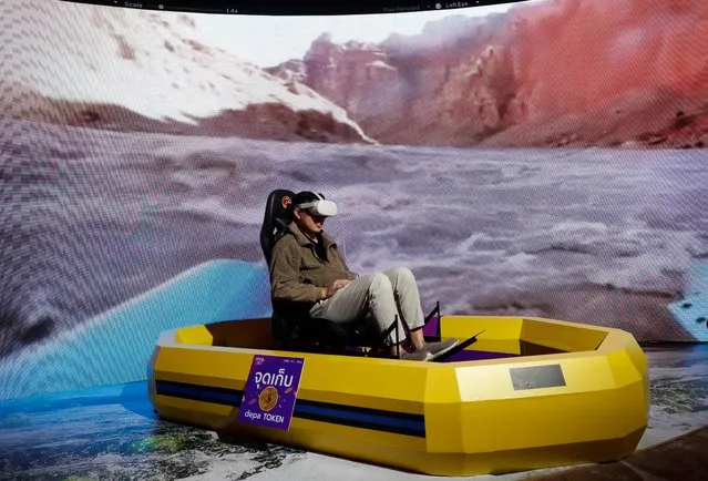 A visitor experiences virtual reality whitewater rafting adventure at HackaThailand 2023 in Bangkok, Thailand on August 25, 2023. The HackaThailand 2023: Digital Infinity is a technology and innovation showcase event held to promote digital platforms development of economy, commerce, tourism, healthiest and games in a bid to drive Thailand as the digital gateway of Southeast Asia. (Photo by Rungroj Yongrit/EPA/EFE)
