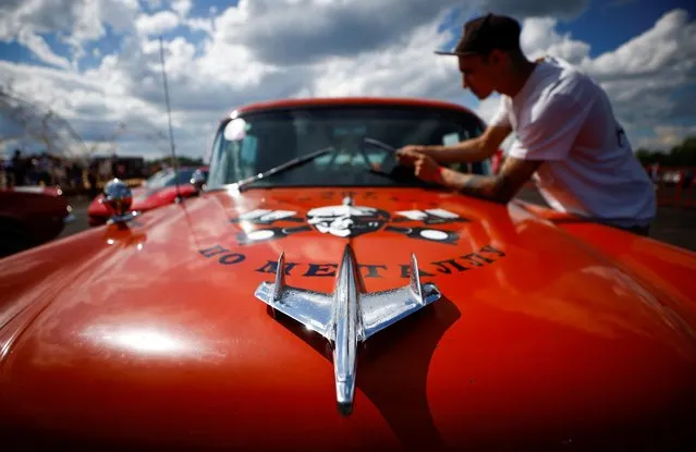 A mechanic adjusts a windshield wiper during the Russian Weekend Drags races of U.S. retro and muscle cars in Bykovo outside Moscow, Russia on May 16, 2021. (Photo by Maxim Shemetov/Reuters)