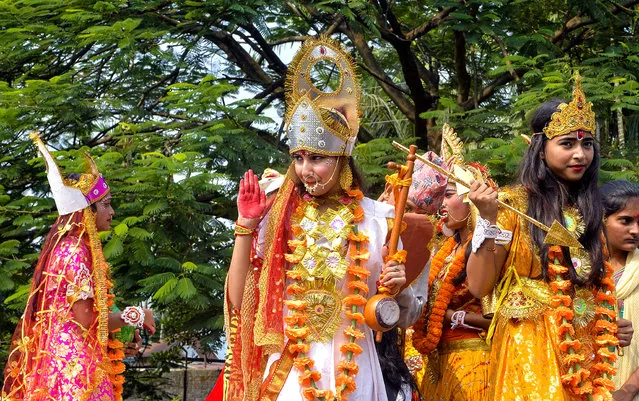 Nepali Hindus who live in India celebrate during the Fulpati procession marking the seventh day of the Dashain festival in Siliguri on October 16, 2018. The five-day Durga Puja festival, celebrated as the Dashain festival in Nepal, commemorates the slaying of the demon king Mahishasur by the goddess Durga, marking the triumph of good over evil with the immersion of idols representing the goddess in water bodies. (Photo by Diptendu Dutta/AFP Photo)