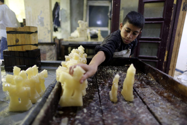 An Egyptian factory worker makes candy dolls for the upcoming celebration of Prophet Muhammad's birthday at a traditional factory in Cairo, Egypt, 10 December 2015. Prophet Muhammad's birthday will be marked on 23 December. Decorating candy dolls in Egypt for this occasion dates back to the time of Fatimid rule. (Photo by Khaled Elfiqi/EPA)