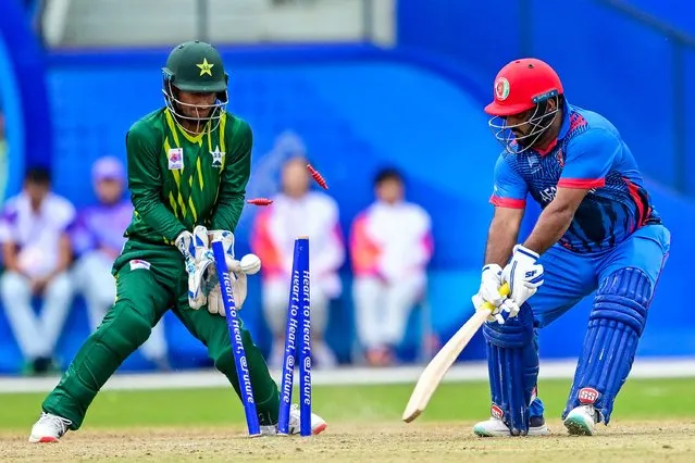 Afghanistan’s Mohammad Shahzad (R) is dismissed by Pakistan’s Arafat Minhas during the 2022 Asian Games men’s second semi-final cricket match between Pakistan and Afghanistan in Hangzhou in China's eastern Zhejiang province on October 6, 2023. (Photo by Ishara S. Kodikara/AFP Photo)