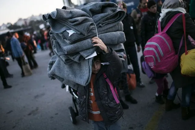 A migrant boy holds blankets as he disembarked from the passenger ferry Blue Star arriving from the Greek island of Lesbos at the port of Piraeus on January 31, 2016 in Athens. More than one million people reached Europe's shores last year – the majority of them refugees fleeing conflict in Syria, Iraq and Afghanistan – in the continent's worst migration crisis since World War II. Most cross by boat from Turkey to Greece and the United Nations said Thursday more than 50,000 people have turned up on the EU member's beaches so far this year, while 200 people died making the dangerous journey. (Photo by Angelos Tzortzinis/AFP Photo)