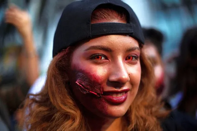 A woman dressed as a zombie looks on during the annual Zombie Walk in Mexico City, Mexico on October 21, 2023. (Photo by Quetzalli Nicte-Ha/Reuters)