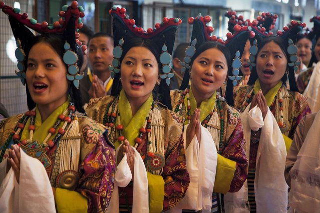 Tibetan artists in traditional costumes sing a welcome song for their spiritual leader the Dalai Lama on his arrival at the Tibetan Institute of Performing Arts in Dharmsala, India, Friday, March 27, 2015. The Dalai Lama watched the first day of the ten-day “Shoton” festival, or the yogurt festival, during which Tibetans eat yogurt and enjoy traditional opera performances. (Photo by Ashwini Bhatia/AP Photo)