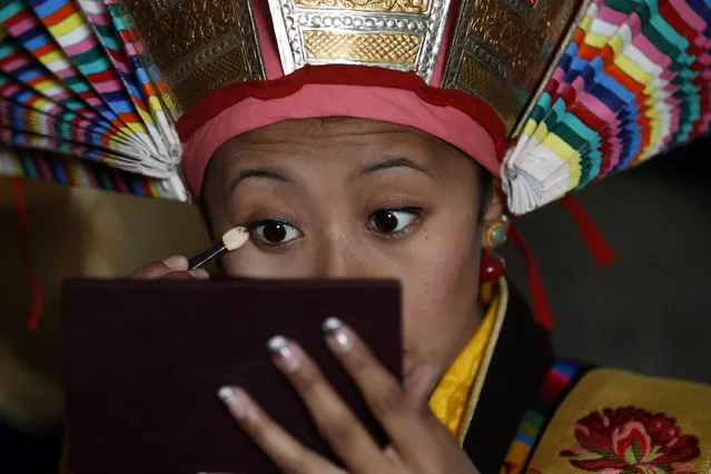 A Tibetan student gets ready in a traditional attire to perform a dance during a special prayer ceremony on the third day of the Tibetan New Year celebrations in Kathmandu, Nepal, Thursday, February 11, 2016. Tibetans follow this ritual called “sangtsol” to ask for good luck in the new year. (Photo by Niranjan Shrestha/AP Photo)