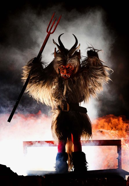 A junior member of the Haiminger Krampusgruppe dressed as the Krampus creature emerges from Hell after having been transformed from a delinquent little boy into the demon-like Krampus, on the town square in Haiming. (Photo by Sean Gallup)