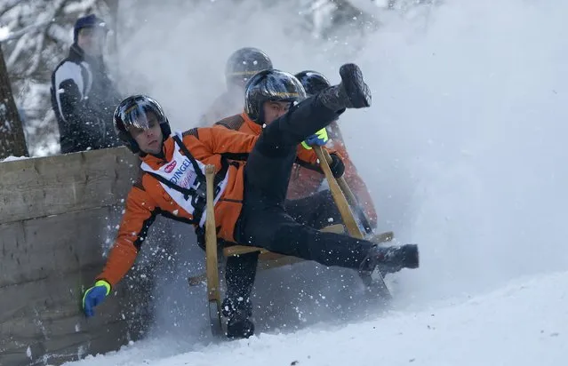 Competitors struggle as they ride their wooden sledge during a traditional Bavarian horn sledge race “Hornschlittenrennen” in Garmisch-Partenkirchen January 6, 2017. (Photo by Michaela Rehle/Reuters)