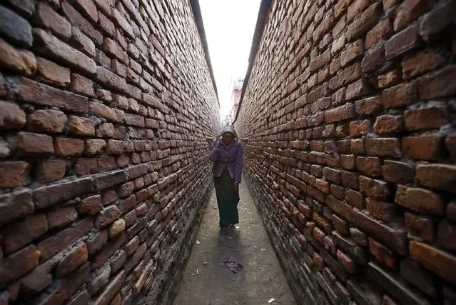 A woman carrying a basket walks down a narrow alley as she returns from the vegetable market in Kathmandu February 9, 2015. (Photo by Navesh Chitrakar/Reuters)