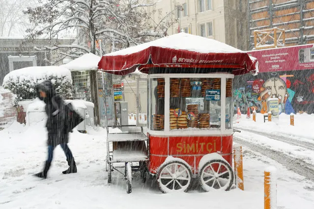 A street vendor sells simit, the traditional Turkish sesamed bread, at the main shopping and pedestrian street of Istiklal during a snowfall in central Istanbul, Turkey January 9, 2017. (Photo by Murad Sezer/Reuters)