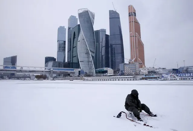 A man fishes on the ice-covered Moskva river near the Moscow International Business Center also known as "Moskva-City" in the capital Moscow, Russia, January 13, 2016. (Photo by Maxim Zmeyev/Reuters)