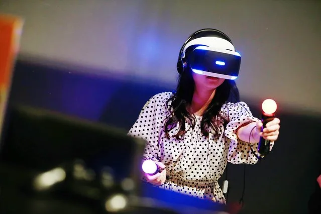 A visitor experiences a Sony PlayStation VR headset during a preview for the exhibition “Game On: Why are videogames so interesting?” at the National Museum of Emerging Science and Innovation, also known as Miraikan, in Tokyo, Japan, 01 March 2016. This special exhibition showcases an overview of how video games have evolved in line with the advancement of computers and information technology. (Photo by Christopher Jue/EPA)