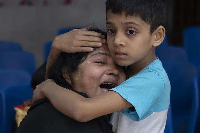 Rakibul, 6, comforts his mother Rehana mourning the death of her husband, Mohammad Zillur, at a hospital in Munshiganj, outside Dhaka, Bangladesh, Sunday, January 7, 2024. Zillur, a supporter of a candidate from the ruling Awami League, was stabbed to death on Sunday as Bangladesh voted in a parliamentary election boycotted by the main opposition party. (Photo by Altaf Qadri/AP Photo)