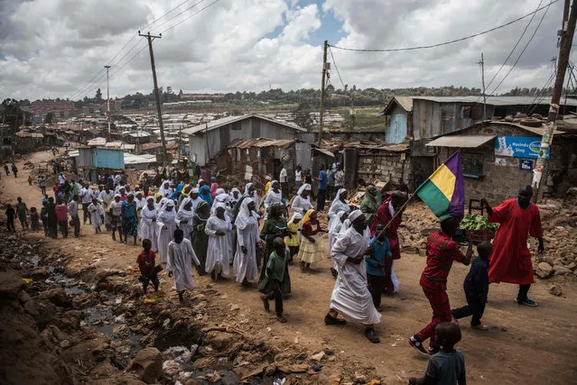 Church members carry twin girls Bridget Lillian and Brillian Mary through Kibera, Africa largest slum, to induct them as new members of the Neema (swahili for grace) on February 28, 2016 in Nairobi. The Neema indigenous church welcome its new members with an “Onywole”, a celebration for newborns. (Photo by Fredrik Lerneryd/AFP Photo)