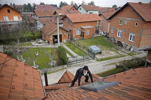 Dajana Djuric, 25,who has worked as a chimney sweep since the age of six, climbs a roof of a house to clean a chimney in Brcko, Bosnia and Herzegovina. Picture taken March 3, 2016. (Photo by Dado Ruvic/Reuters)