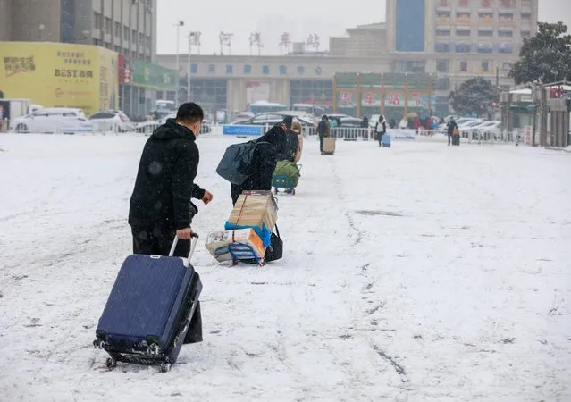 Travelers drag luggage through heavy snow at Luohe Railway Station during the Spring Festival travel rush on February 2, 2024 in Luohe, Henan Province of China. (Photo by Yang Guang/VCG via Getty Images)