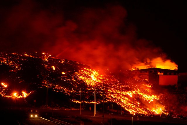 Lava burns buildings following the eruption of the Cumbre Vieja volcano in Tacande, Spain, October 9, 2021. (Photo by Juan Medina/Reuters)