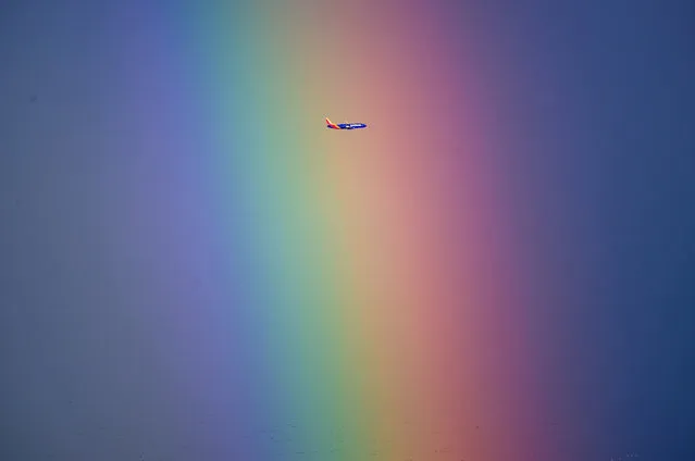 A Southwest Airlines plane flies through a rainbow as it departs from Sacramento, California on February 19, 2024. Threats of tornadoes, waterspouts and localized flooding has many Californians on high alert as storms continue to bombard the state. (Photo by Josh Edelson/AFP Photo)
