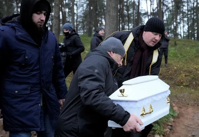 A Polish imam, right, and two other members of a Muslim community bury the tiny white casket of an unborn Iraqi boy, in Bohoniki, Poland, on Tuesday November 23, 2021. The child is the latest life claimed as thousands of migrants from the Middle East have sought to enter the European Union but found their path cut off by a military build-up and fast approaching winter in the forests of Poland and Belarus. (Photo by Czarek Sokolowski/AP Photo)